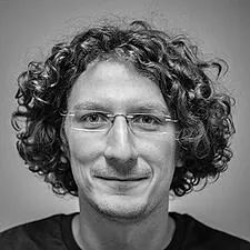 Portrait d'un homme aux cheveux bouclés et à lunettes